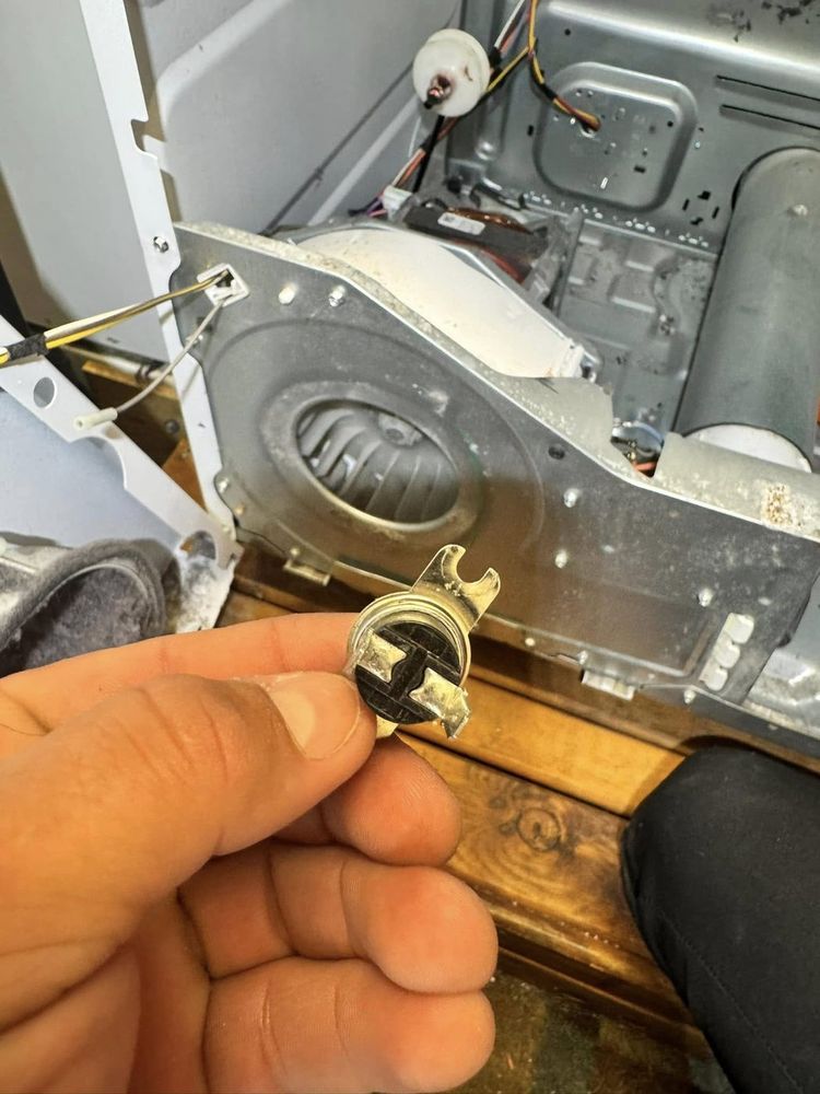 A dryer opened down to the blower housing — the failed part comes out, a new one goes in.