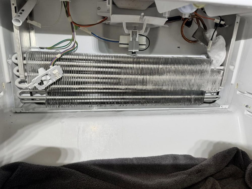 Evaporator coils exposed on a refrigerator — this is where most cooling problems are found and fixed.