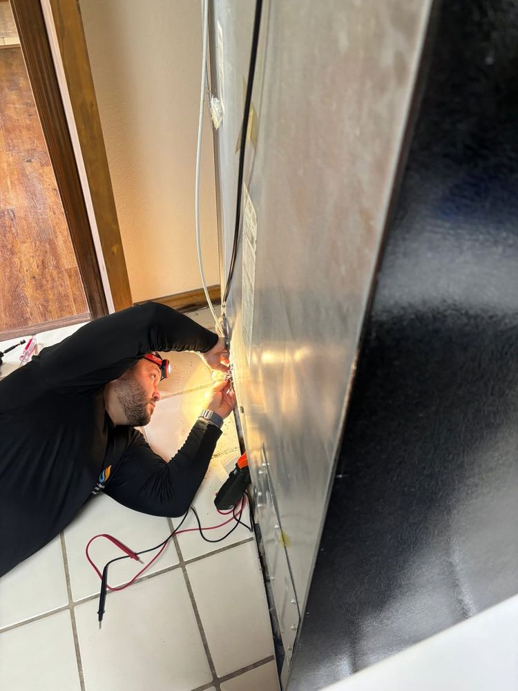 Meter on the terminals behind a refrigerator: diagnosis first, so you're quoted a repair that actually fixes it.
