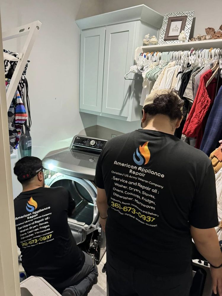 Two technicians working a stacked laundry closet — tight spaces are part of the job in Coastal Bend homes.