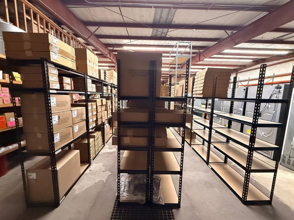 The parts warehouse keeps growing — new shelving going up to hold even more inventory.